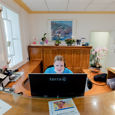 Mitarbeiterin am Empfang der Klinik beantwortet Telefonanrufe – freundlicher Service und professionelle Patientenbetreuung.