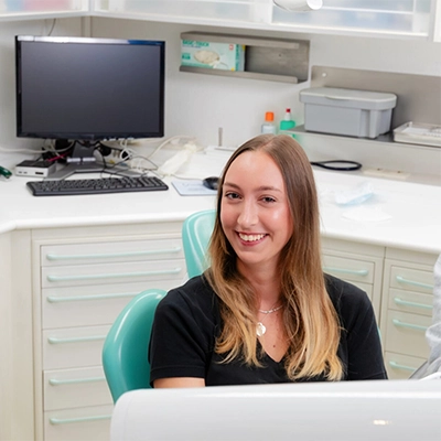 Patientin lächelt im Behandlungsraum, während sie zahnärztlich betreut wird – entspannte Atmosphäre und professionelle Behandlung in Suderburg.